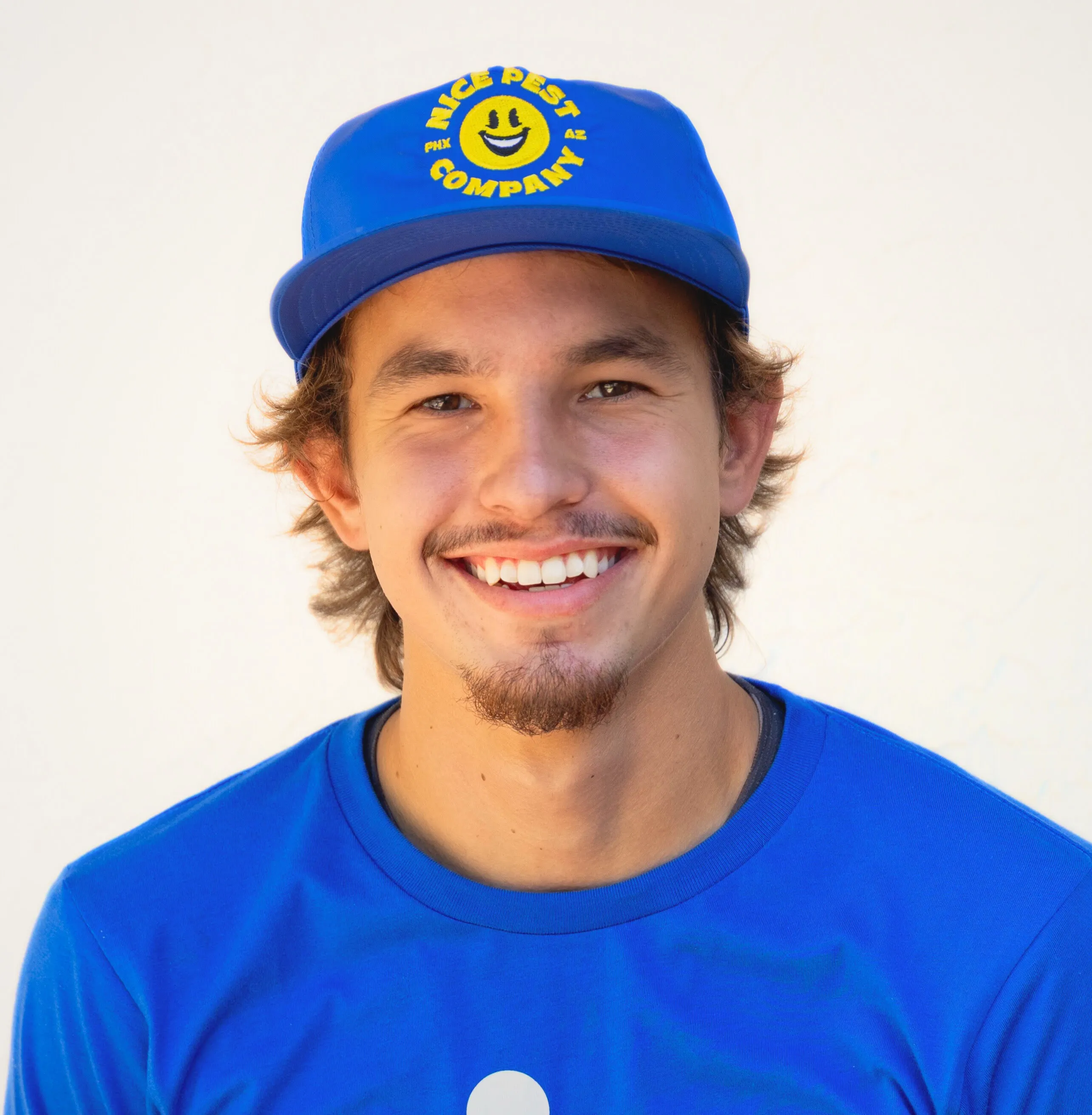 Neo Henderson wearing a blue Nice Pest Company shirt and cap