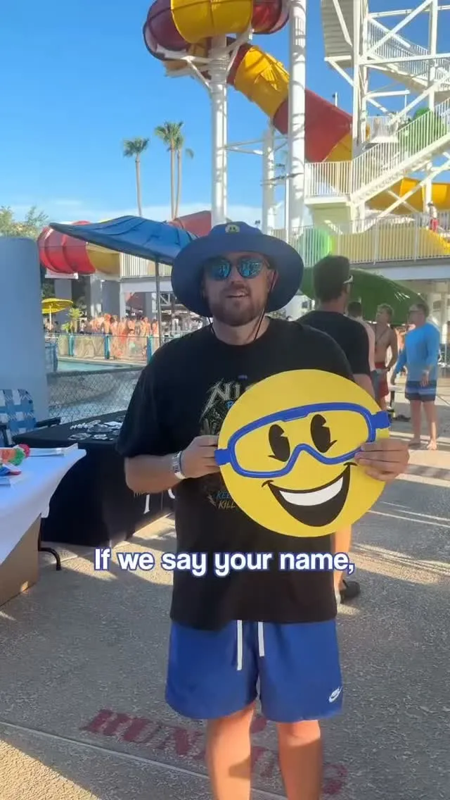 A Nice Pest Company team member holding the Nice smiley-face sign at a water park