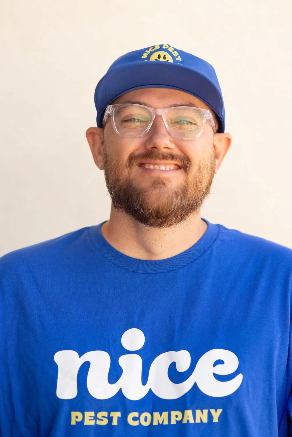 Travis Bottoms wearing a blue Nice Pest Company shirt and cap