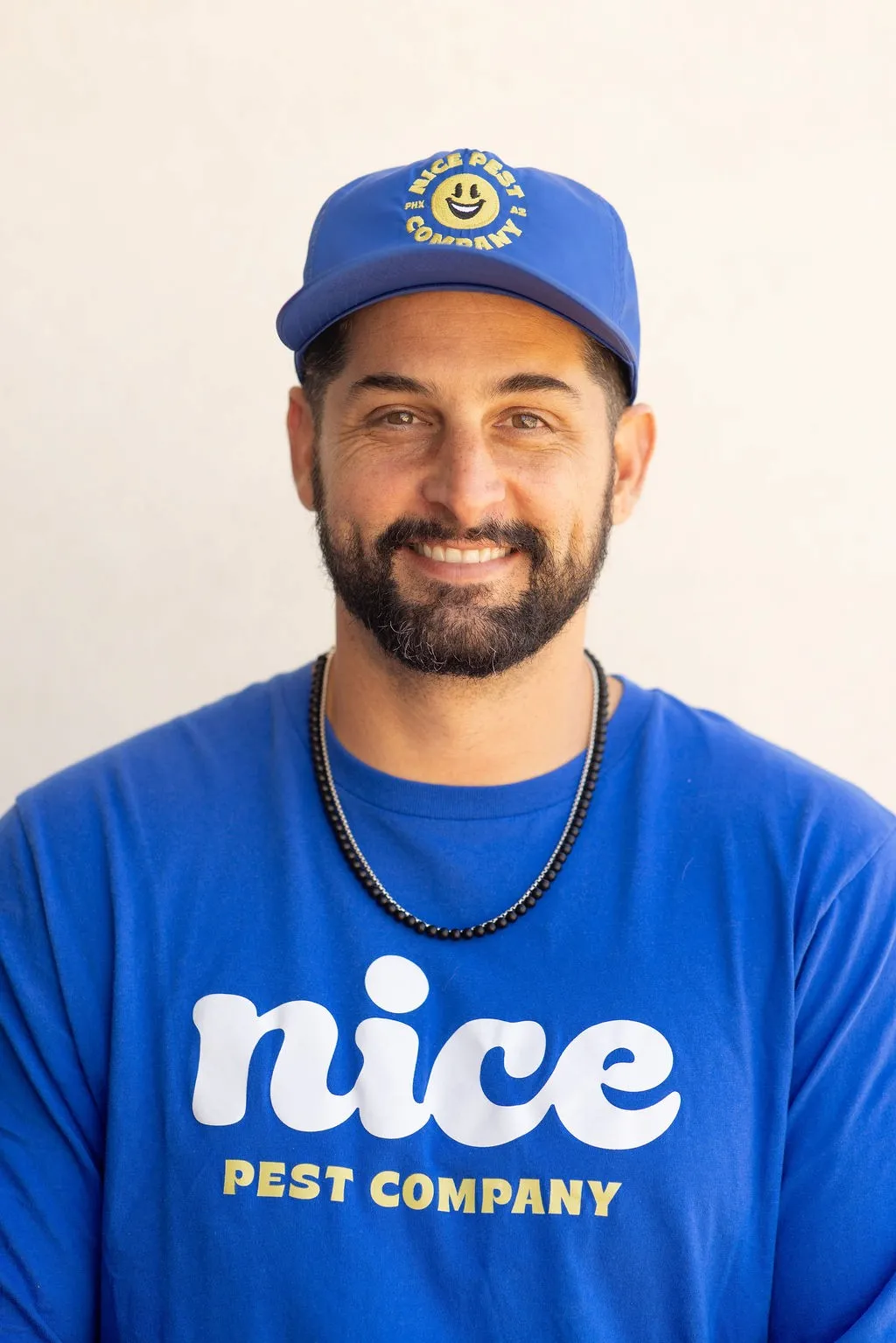 Tyler Sublette wearing a blue Nice Pest Company shirt and cap